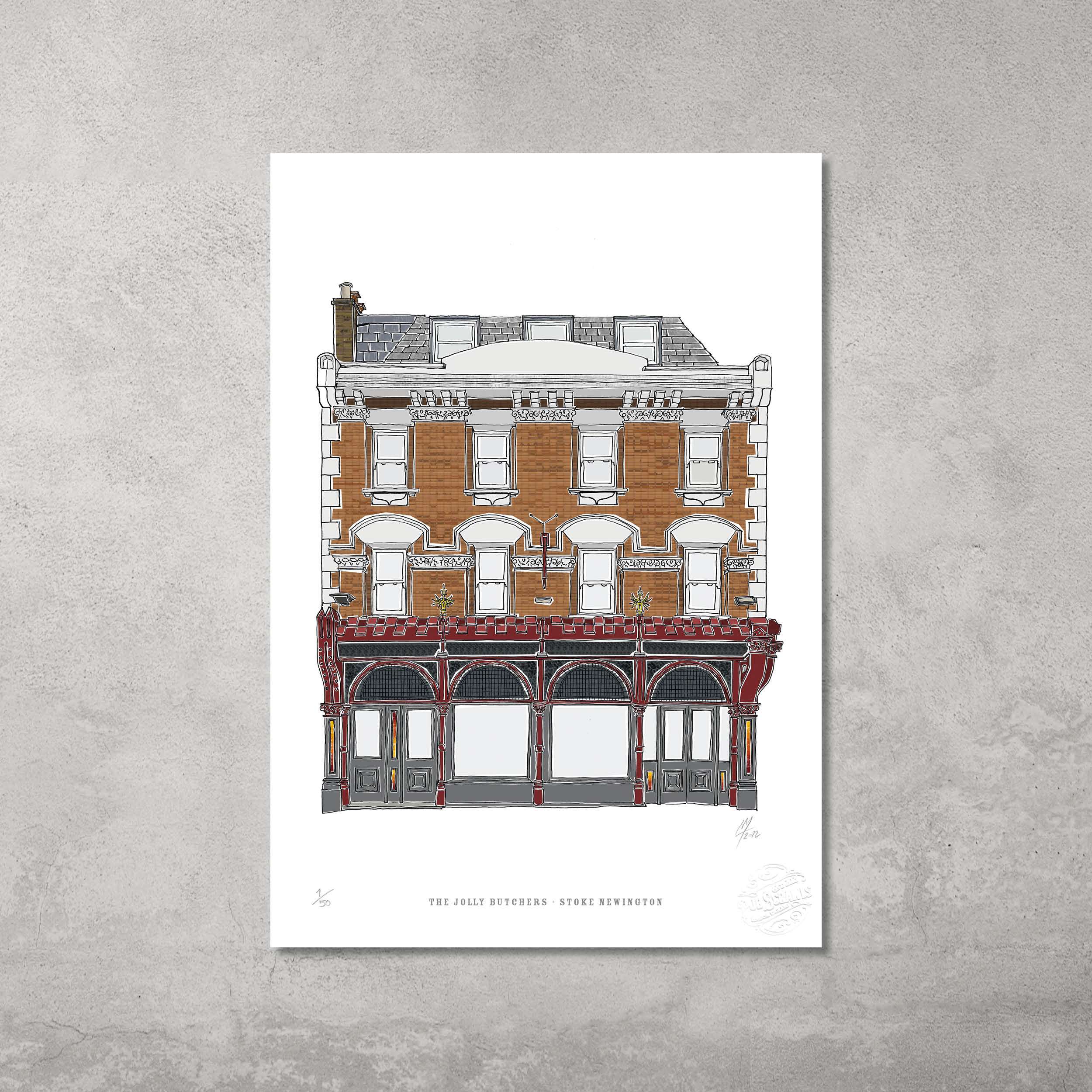 A Victorian-style pub with ornate details, large windows, and flower boxes is depicted in this A3 giclée print. Limited edition of 50 by 45 Original. Displayed on a gray wall; text below: The Jolly Butchers – Stoke Newington.
