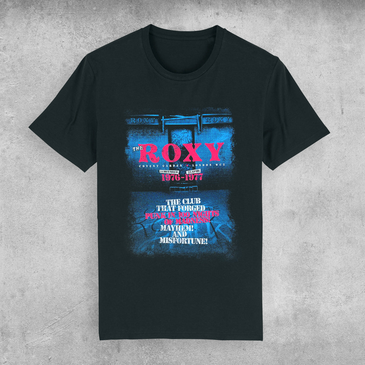 The Roxy Club T-Shirt by My Store—limited edition of only 100—features a distressed blue and pink “The Roxy” graphic and “The club that forged punk rock’s spirits, mayhem and misfortune!” Laid flat on concrete.